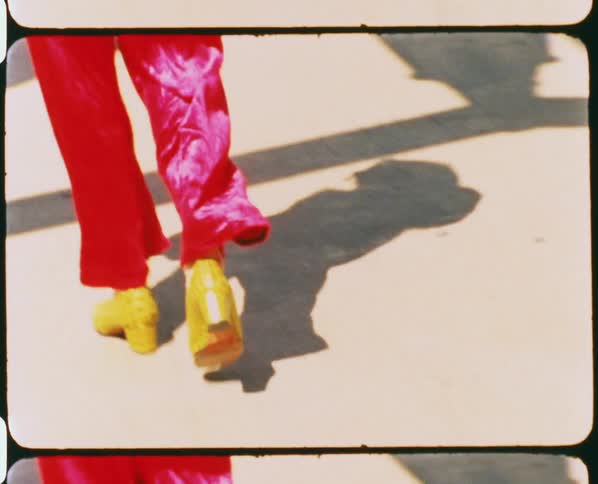 Vintage footage of a womans legs as she walks along pavement