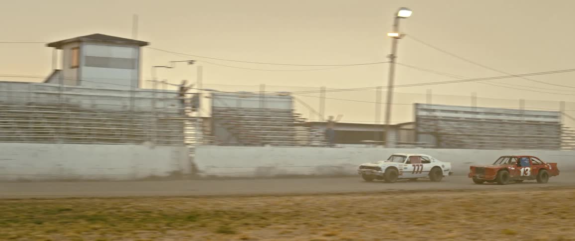 Vintage vehicles race around an empty track