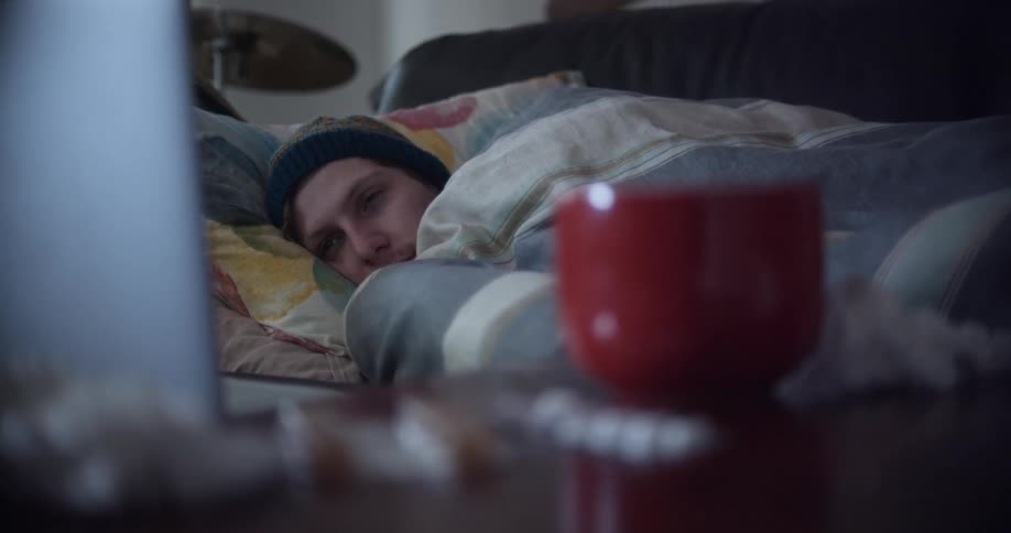 Young man with COVID resting on the couch at home