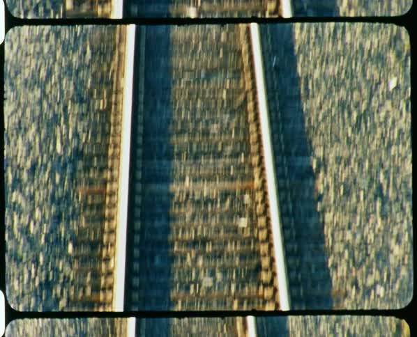 A railway leading under a bridge in a city during the day