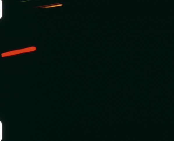 Multi colored streaks and dashes of light move across blackness