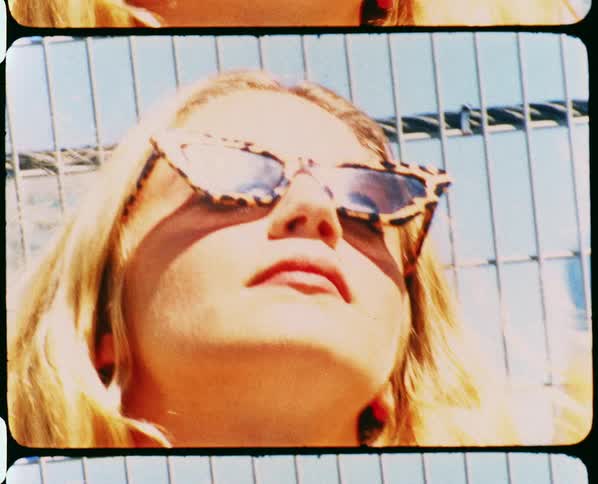 Footage of a woman standing in a downtown city is displayed