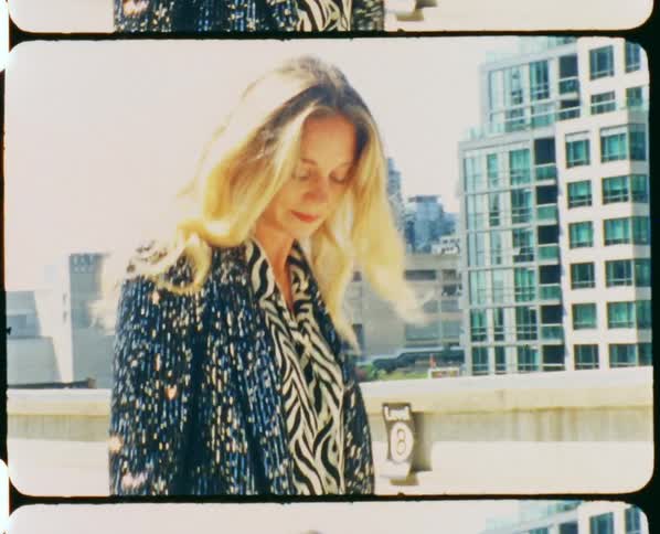 A woman standing on the top of a parking garage and moving around