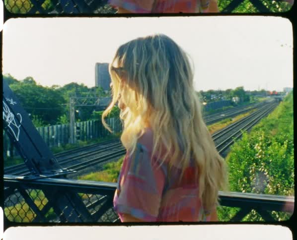 A woman looks back as she crosses a metal bridge
