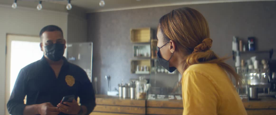 A woman wearing gloves is working in a room surrounding by bottles