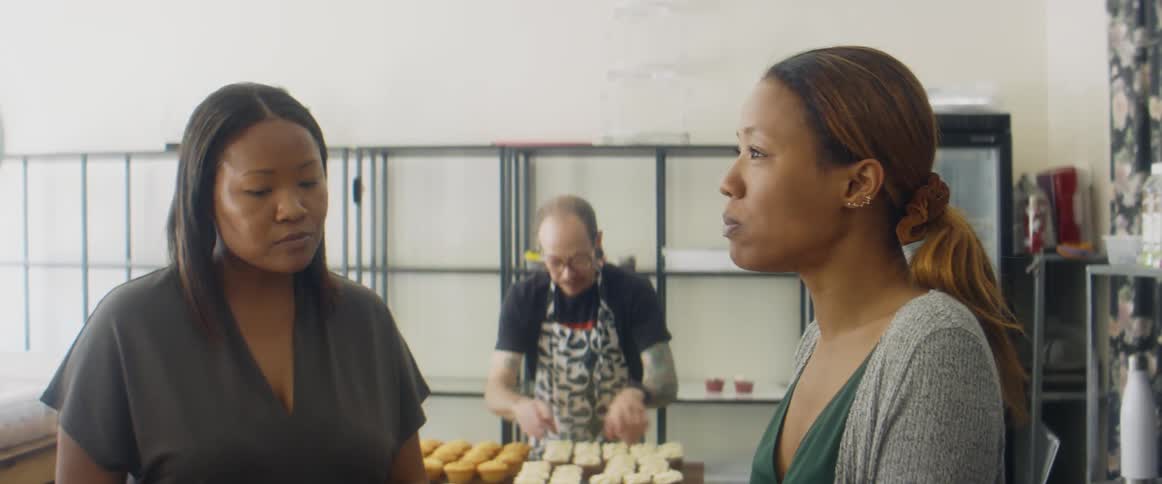 Two women tasting sweets on a shop