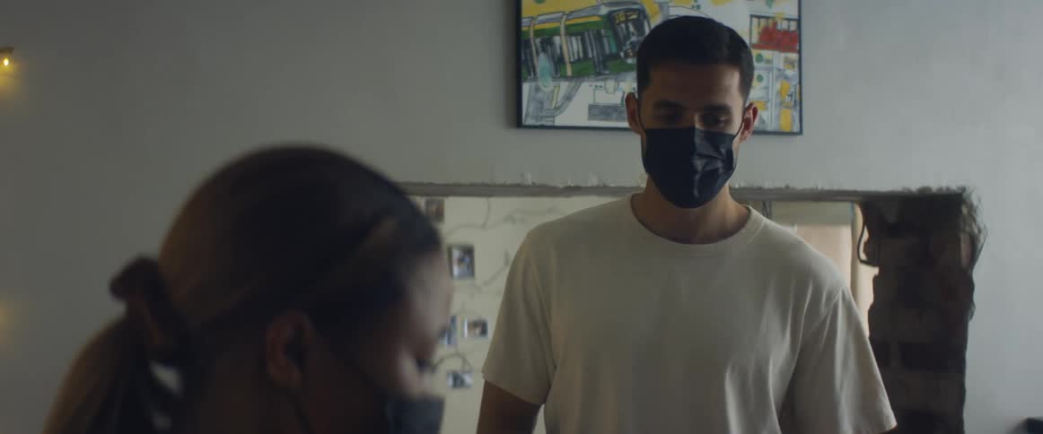 A woman hands a man a bag after he walks into the room she is in