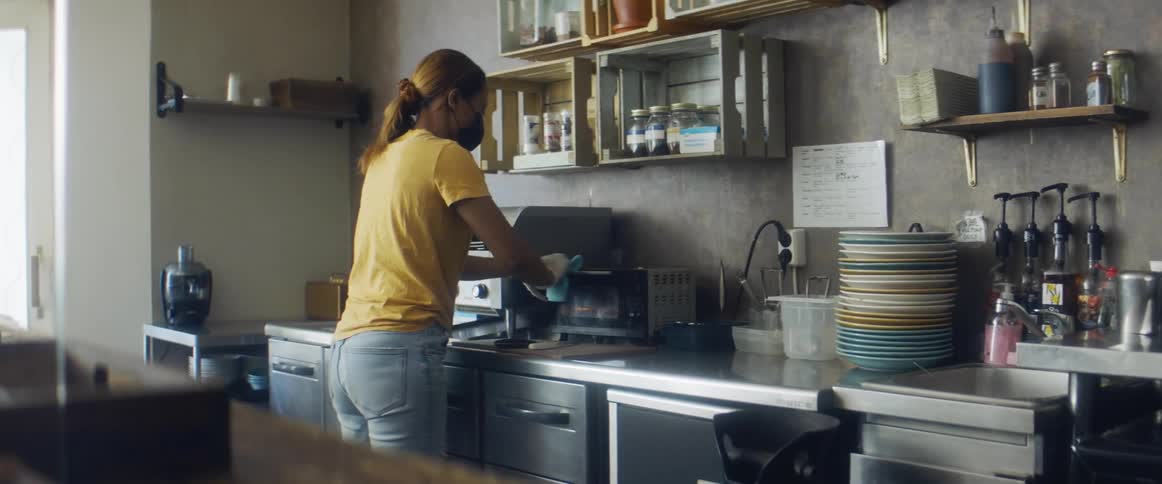 An employee cleaning up a coffee machine in a shop
