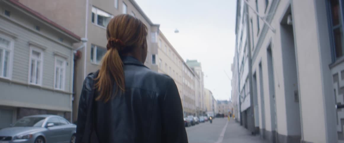 A woman walking around in a city in the day