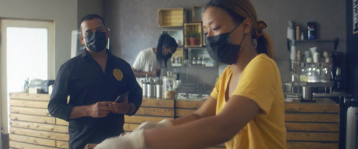 Store owner delivering an order to a customer in the shop