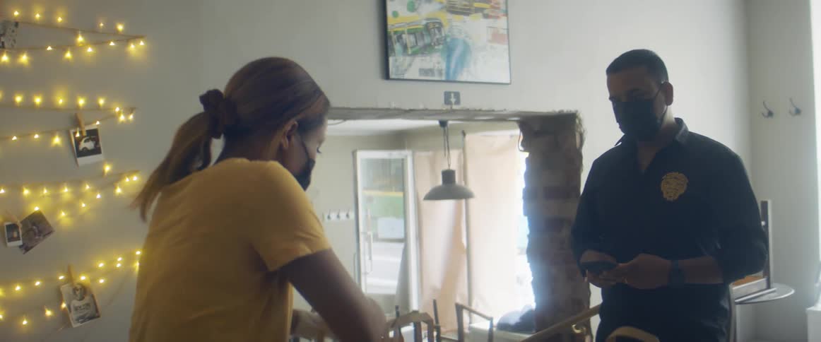 A woman places togo containers in a bag that a man picks up and leaves with