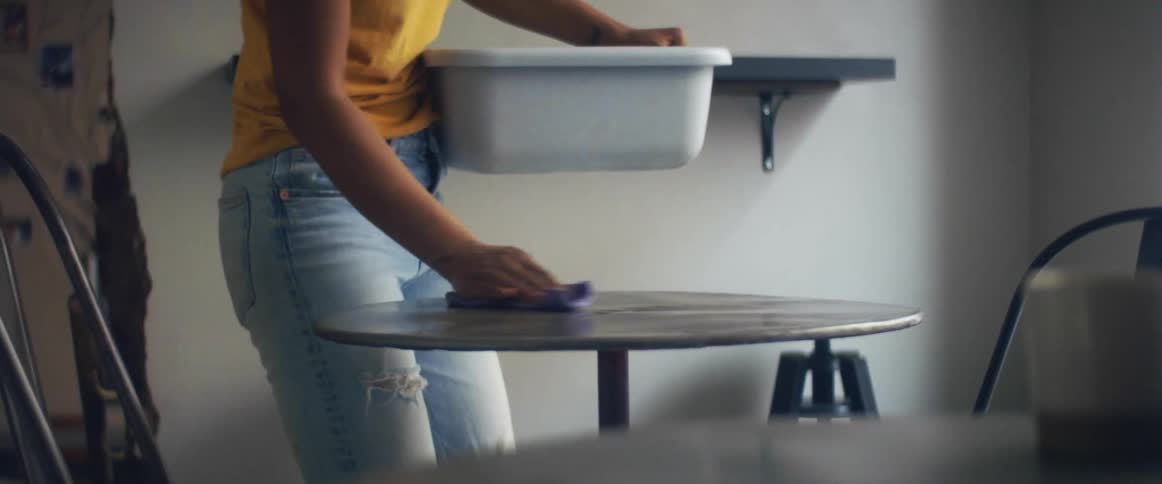A woman is cleaning the tables with a rag