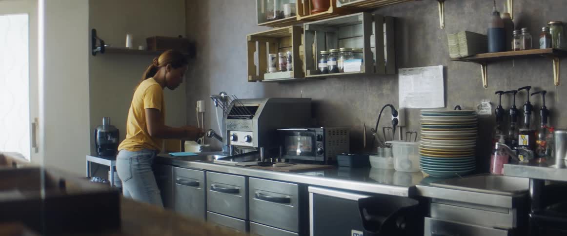 A woman cleaning dishes in a kitchen