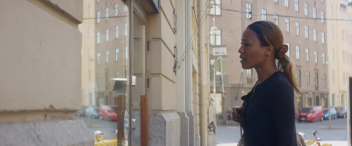 A woman is walking through a downtown city during the day