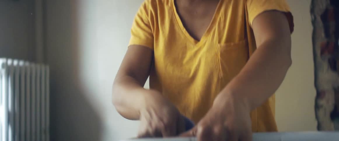 A woman is bussing a table in a restaurant