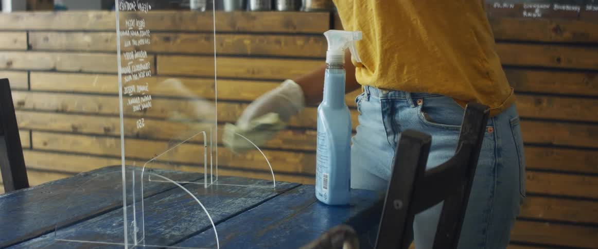 A woman cleaning up a sign at a store