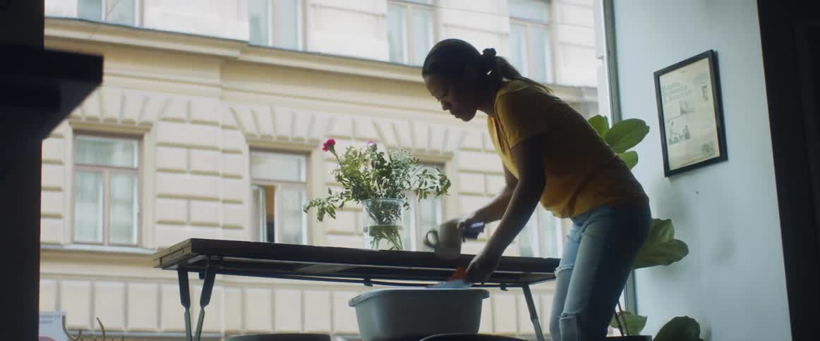 An employee wiping off a table in a shop