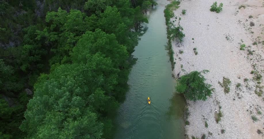 A yellow boat paddles down a river