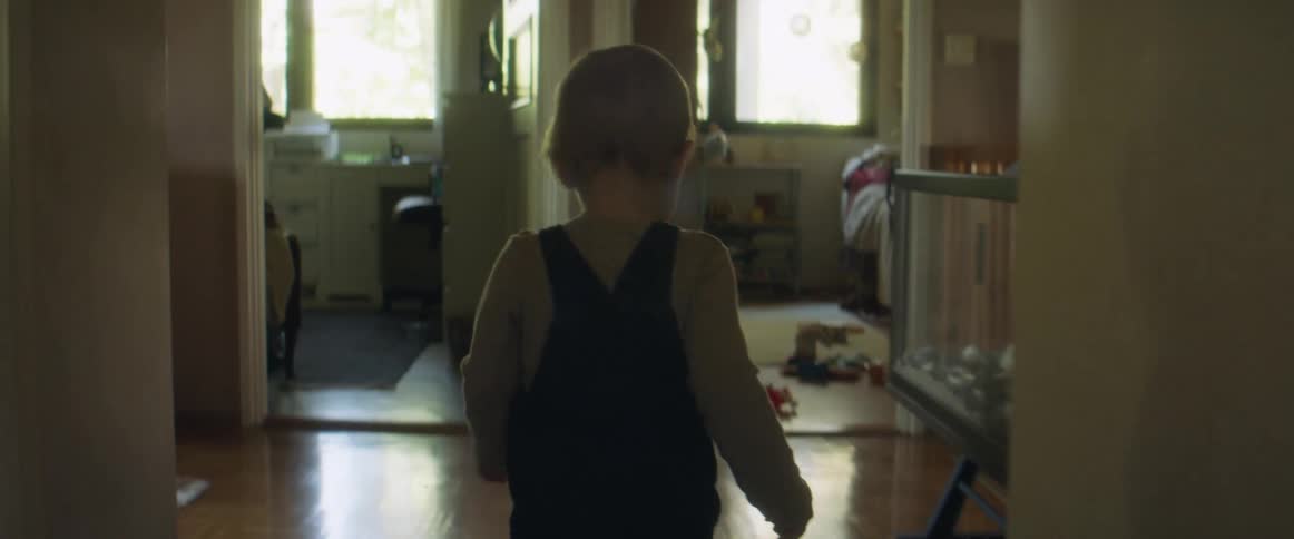 Blonde toddler walking on the hallway at home