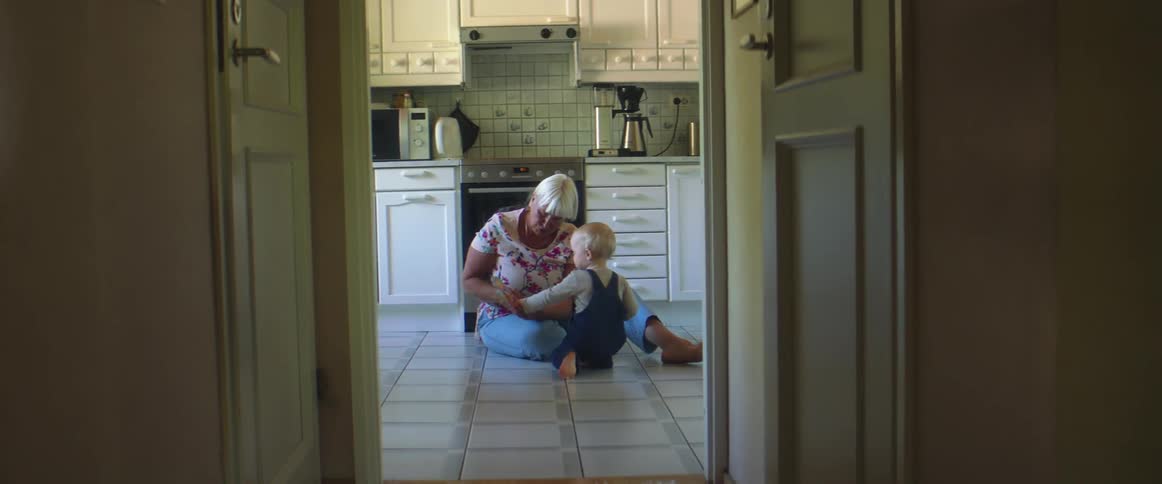 A grandmother and granddaughter playing in a kitchen