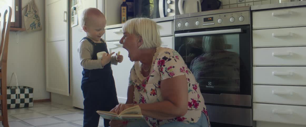 A child feeds a cookie to his grandmother