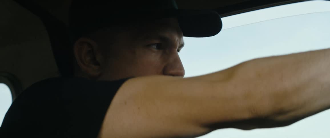 A man is drives a vehicle aggressively during the day