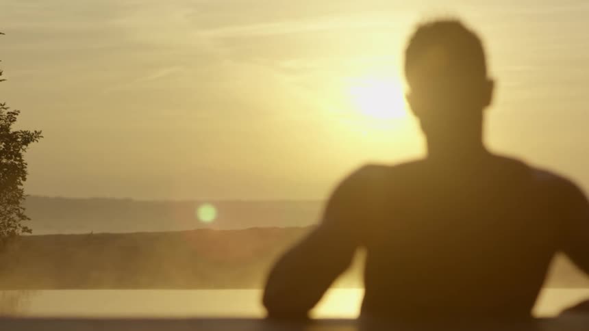 A man standing in front of a sunset