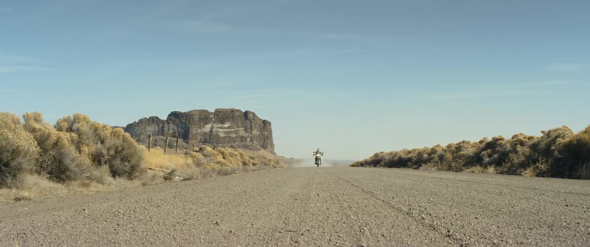 A man rides his motorcycle down the road