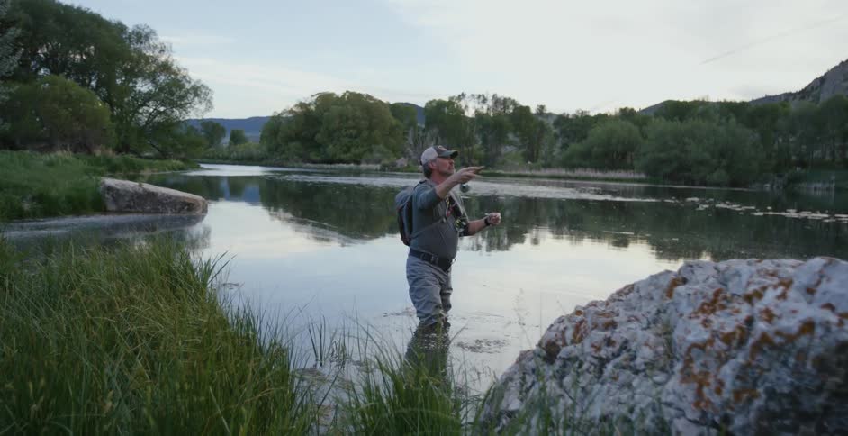 Man standing on a river fly fishing at morning
