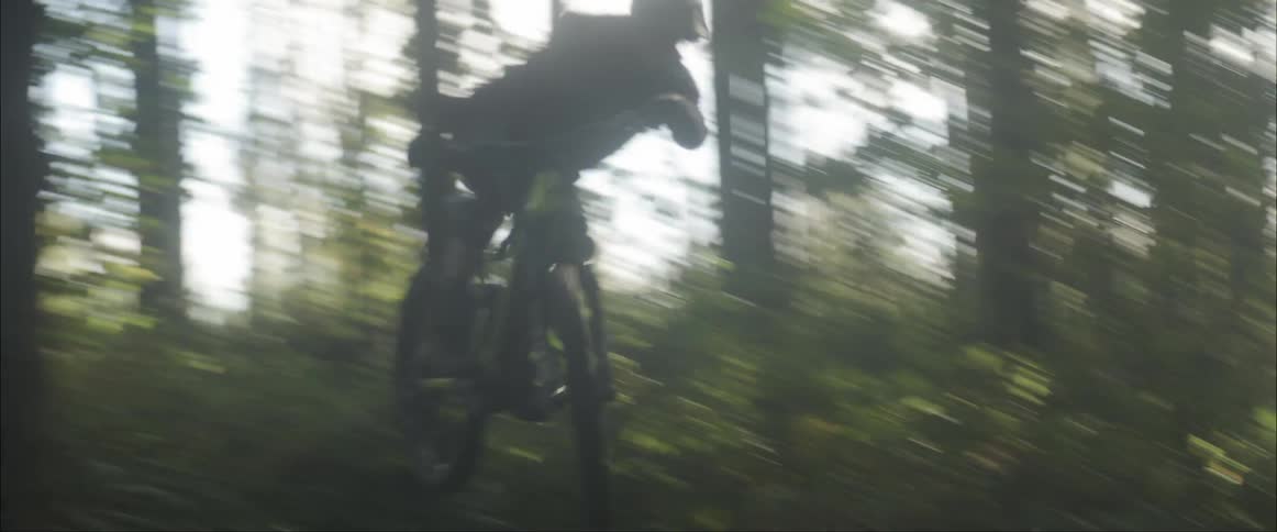 A man riding a mountain bike through a trail in a forest