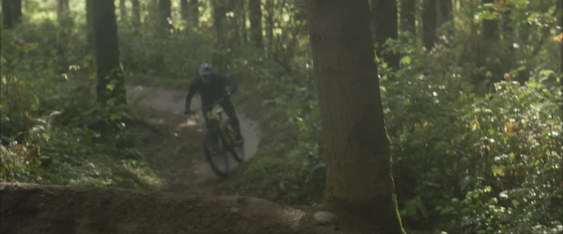 A man riding a mountain bike through a trail in a forest