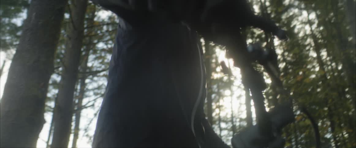 Cyclist wearing a helmet pushes a bicycle through the forest