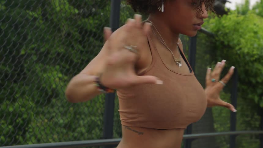 Young energetic woman dancing on a bridge in a small town