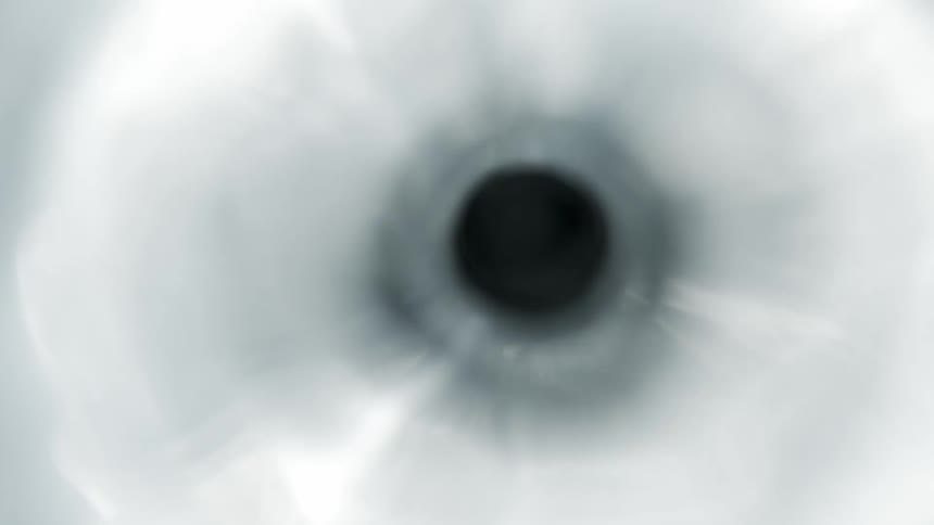 Liquid flows swiftly into a small hole which causes it to ripple as it moves