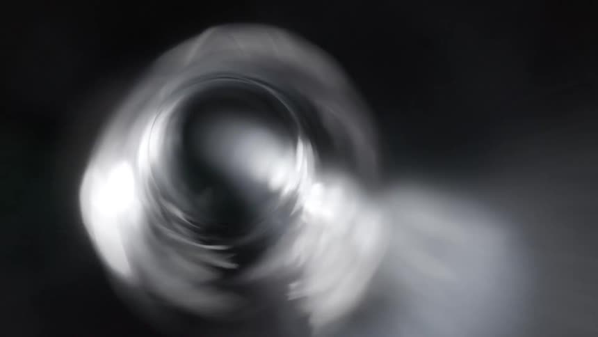 Translucent material spins creating partly shadowed partly shiny vortex