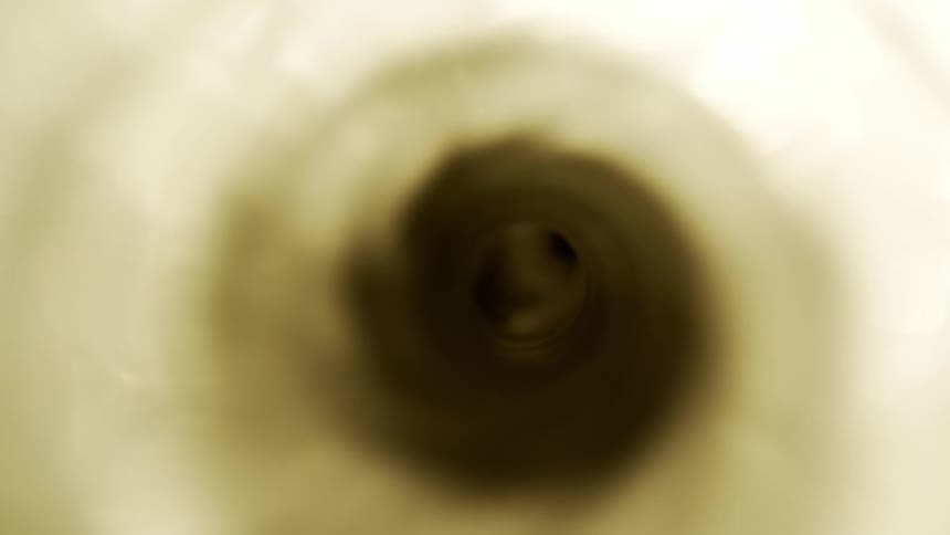 Dark sediment gathers in the middle of a centrifuge as it spins faster and faster
