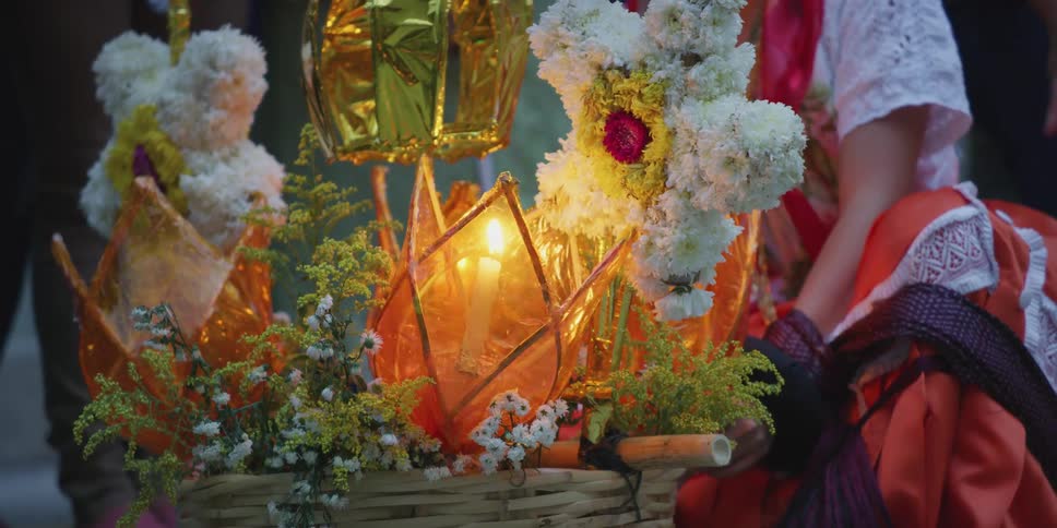 A woman in a dress next to a basket with flowers and candles
