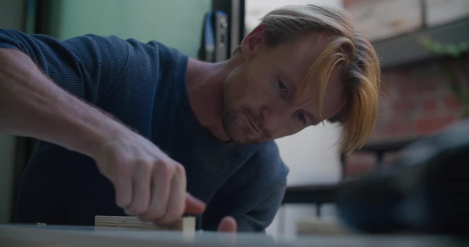 An employee working on a piece of wood in a shop