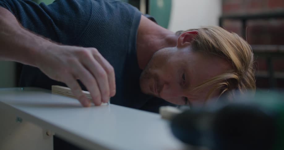 An employee working on some wood in a shop
