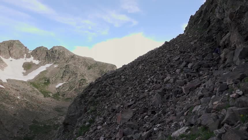 A rocky hill on a mostly clear day