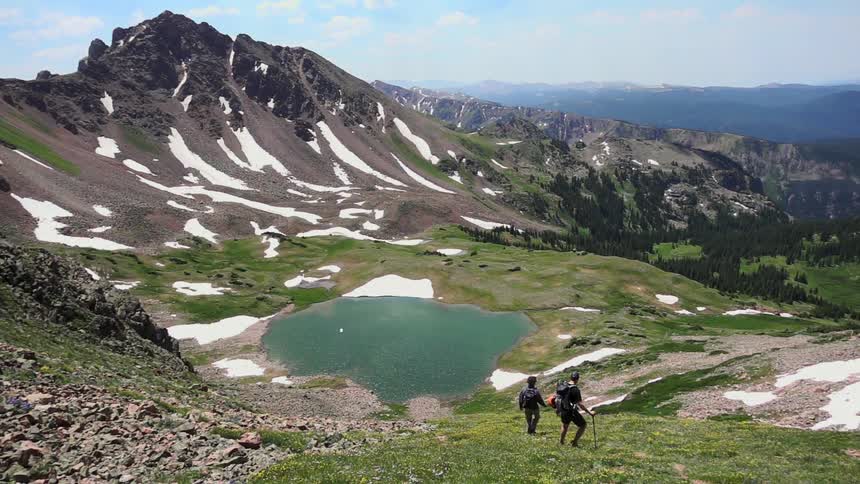 Two people are hiking downhill