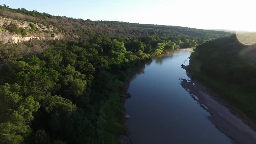 A river crosses between two hills at sunset