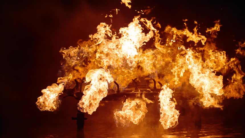 A structure is engulfed in flames and burning brightly
