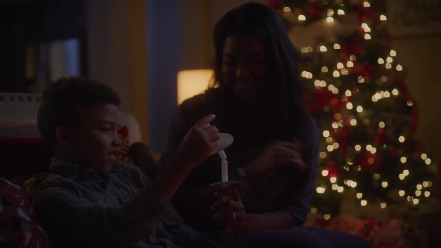 A mother and child sitting together with candles