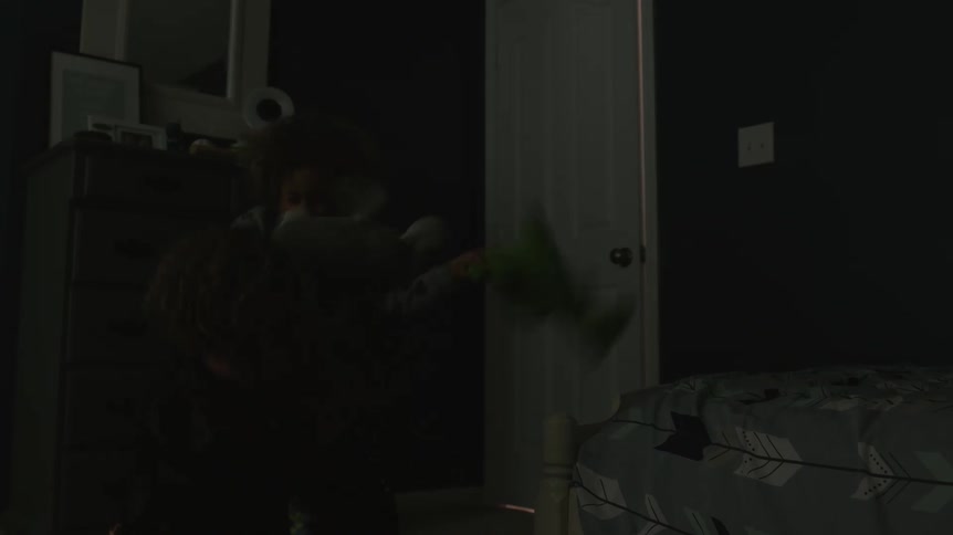 Two children are playing in their room at night as the father opens the door to check on them