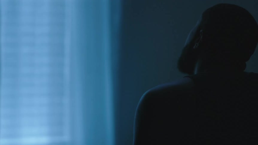 A man sitting and contemplating in a bedroom