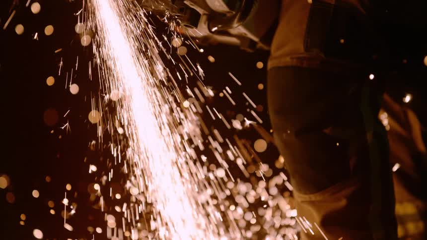 Firefighter cutting metal with a power tool at night