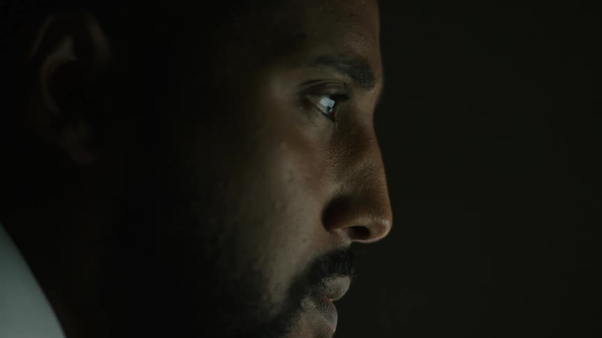 A man in a room with a wall in the background