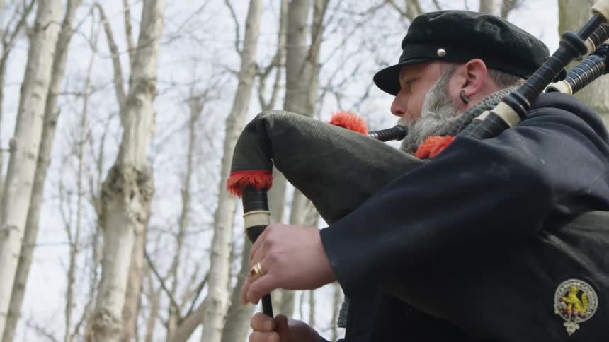 A man plays the bagpipes outside
