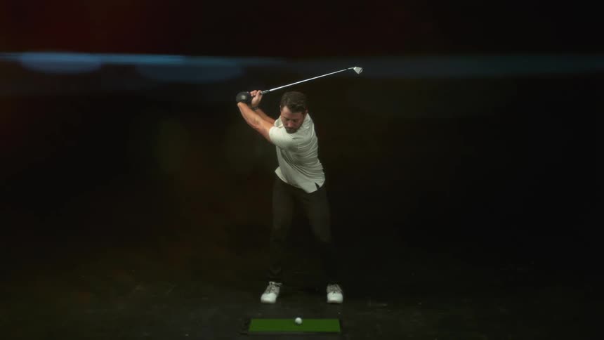 A slow mo of a man hitting a golf ball